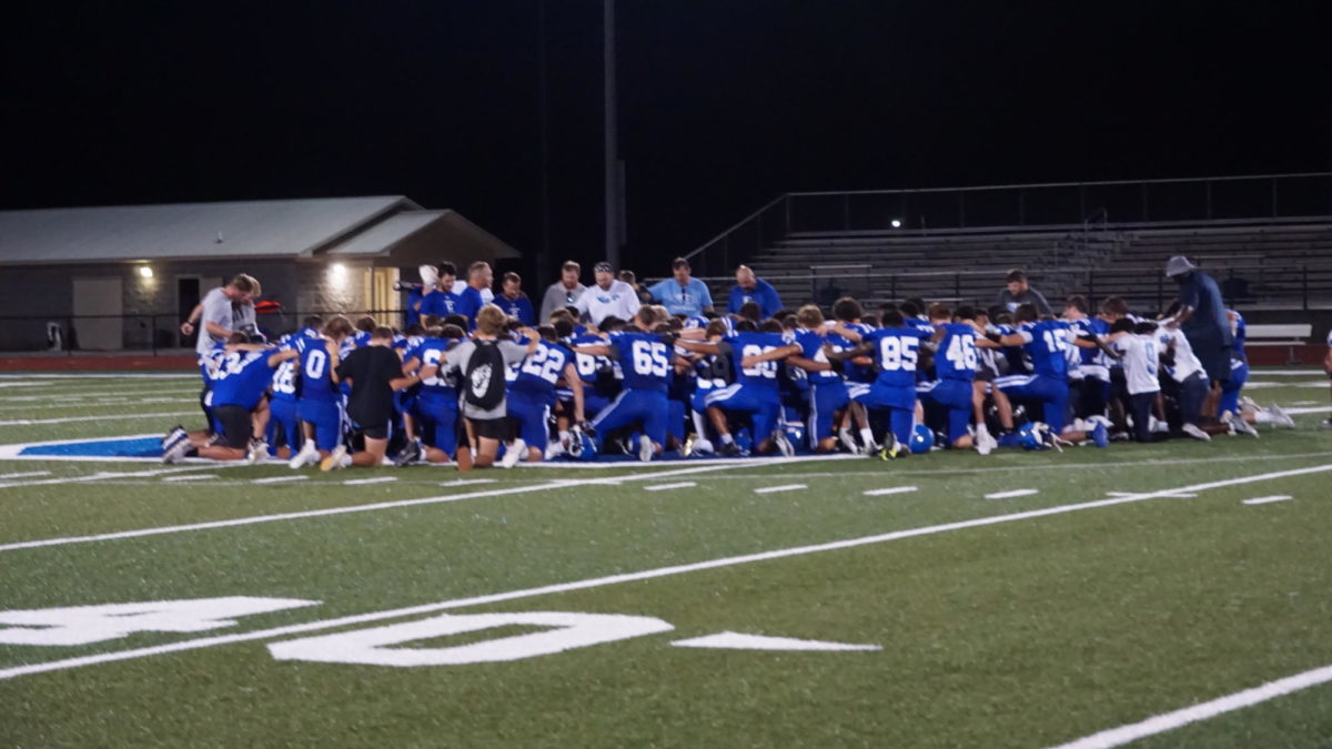 The players huddle up for encouragement after the game, and have a moment of prayer over the loss of Calera player and student Brayden Ray.